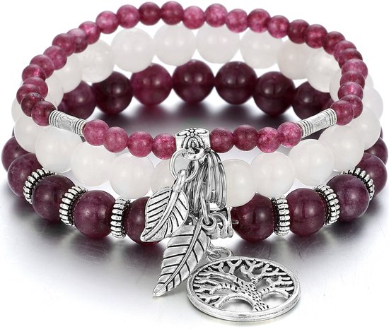 Trois bracelets empilés avec des perles violettes et blanches alternées, des entretoises argentées et des breloques.