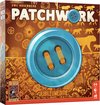 Doos van het spel Patchwork Jubileumeditie, met een grote blauwe knoop op de voorkant en gouden patronen.