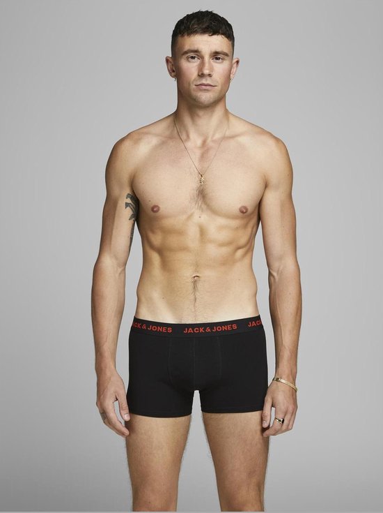 Man draagt zwarte boxer met rode 'JACK & JONES' tailleband.