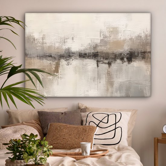 Peinture abstraite dans des tons beige, gris et brun avec des reflets sur un lit avec des coussins.