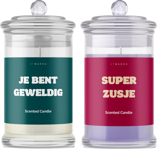 Twee glazen geurkaarsen met deksel. Eén met groen label 'JE BENT GEWELDIG', één met rood label 'SUPER ZUSJE'.