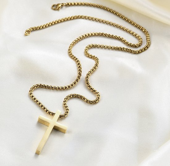 Gouden kruisketting met dikke schakel, liggend op glanzend crèmekleurig satijn.