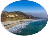 PVC Schuimplaat Ovaal - Oceaan Aanstromend bij Strand aan Rand van de Berg - 56x42 cm Foto op Ovaal (Met Ophangsysteem)