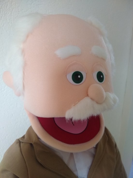 Poppenhoofd met glimlachend gezicht, witte haren, groene ogen en een bruin jasje.