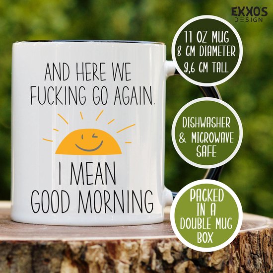 Witte mok met zwarte rand en oor, met informatiecirkels. Tekst: "AND HERE WE FUCKING GO AGAIN. I MEAN GOOD MORNING" met zon.