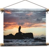 Textielposter - Vrouw op Rotsen Kijkend naar de Zee - 40x30 cm Foto op Textiel