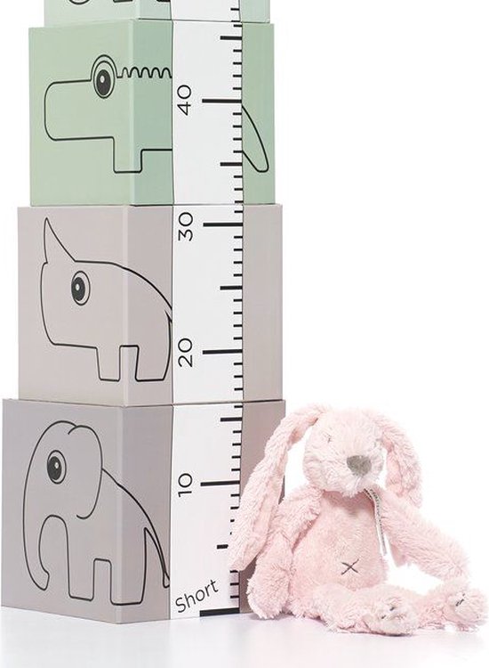 Roze konijnenknuffel naast stapelbare blokken met dieren en een meetlat.