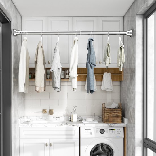 Zilverkleurige uitschuifbare gordijnroede met kleding erin gehangen in een wasruimte.