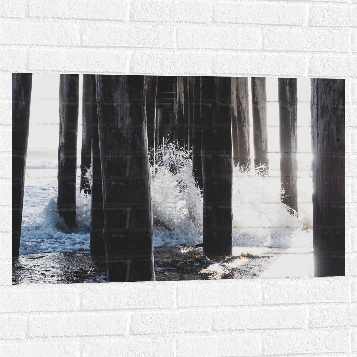 Muursticker - Water klots4end tegen Houten Palen in de Zee - 90x60 cm Foto op Muursticker