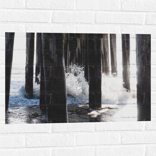 WallClassics - Muursticker - Water klots4end tegen Houten Palen in de Zee - 75x50 cm Foto op Muursticker