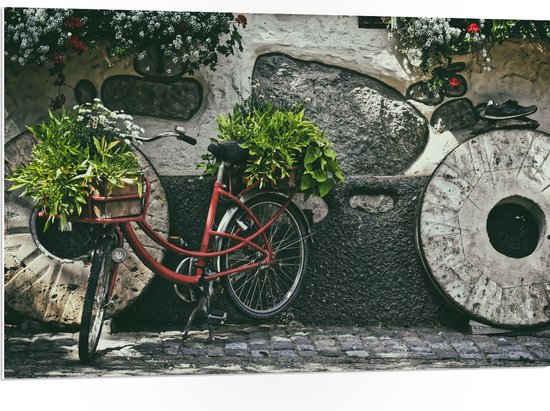 WallClassics - PVC Schuimplaat- Rode Fiets versierd met Planten tegen Stenen Muur - 105x70 cm Foto op PVC Schuimplaat
