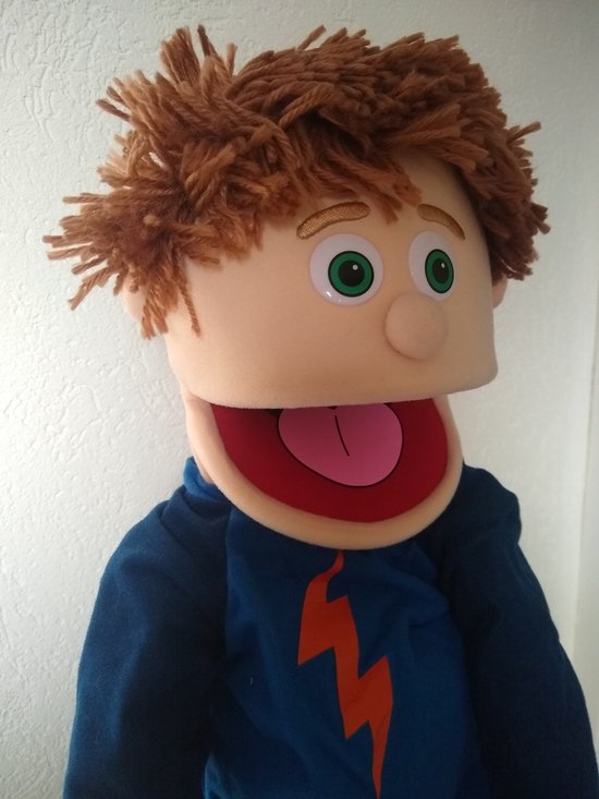 Handpop Tommie met warrig bruin haar, sprekende mond met roze tong en blauw shirt.