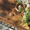 Close-up van een donkerbruin houten oppervlak met een schaal met witte bloemen en een paar losse bloemen.