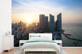 Behang - Fotobehang Zonsopkomst achter de hoge gebouwen in Busan - Breedte 600 cm x hoogte 400 cm