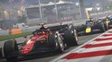 Een rode Formule 1-auto met de nummer 1 en het Ferrari-logo, die wordt gevolgd door andere auto's op een racecircuit.