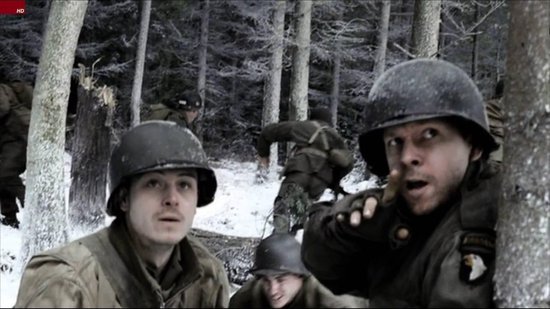Militairen in helmen en winterkleding in een besneeuwd bos, sommigen wijzen en kijken bezorgd.