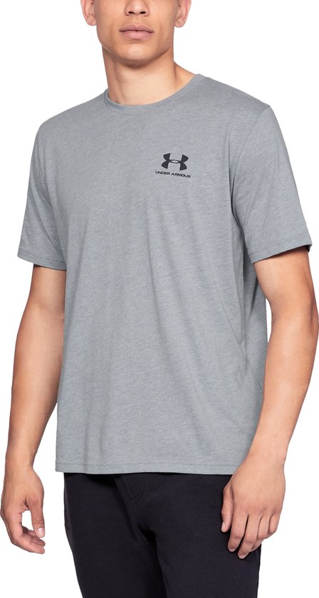 Man draagt grijs Under Armour sportshirt met zwart logo op de borst.