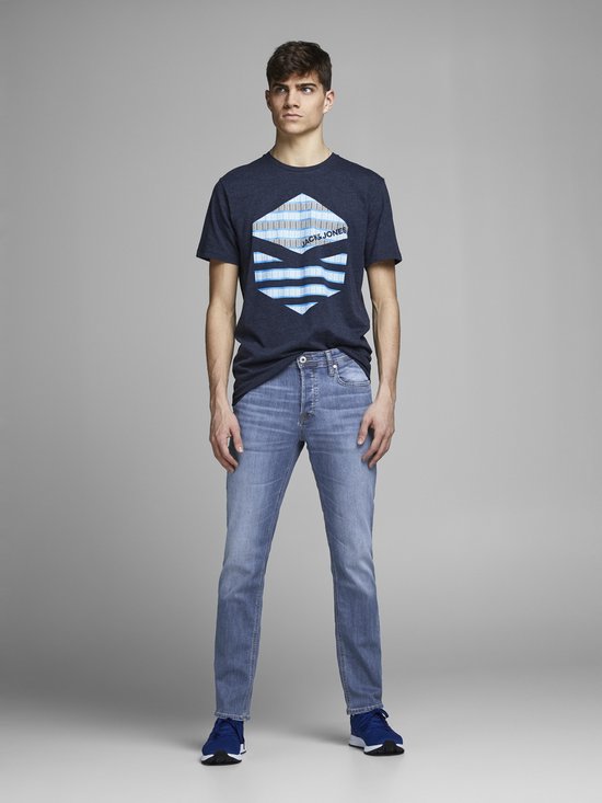 Man in donkerblauw t-shirt met Jack & Jones print en lichtblauwe jeans. Staand, vooraanzicht.