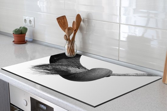 KitchenYeah® Inductie beschermer 76x51.5 cm - Close-up van de slurf een jonge olifant die zijn moeders staart vasthoudt - zwart wit - Kookplaataccessoires - Afdekplaat voor kookplaat - Inductiebeschermer - Inductiemat - Inductieplaat mat
