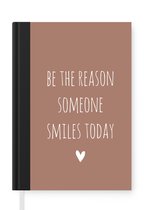 Notitieboek - Schrijfboek - Engelse quote "Be the reason someone smiles today" met een hartje op een bruine achtergrond - Notitieboekje klein - A5 formaat - Schrijfblok