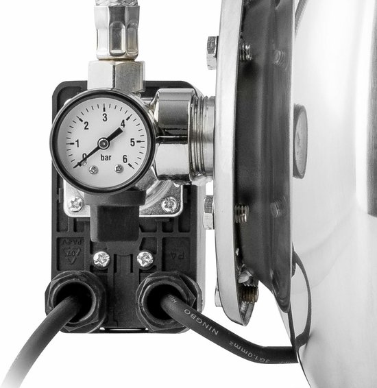 Close-up van een drukmeter op de zwarte bedieningskast van een RVS hydrofoorpomp.