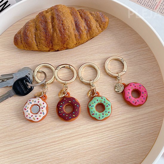 Vier donut sleutelhangers: wit met stippen, bruin met stippen, groen met stippen en roze met stippen.
