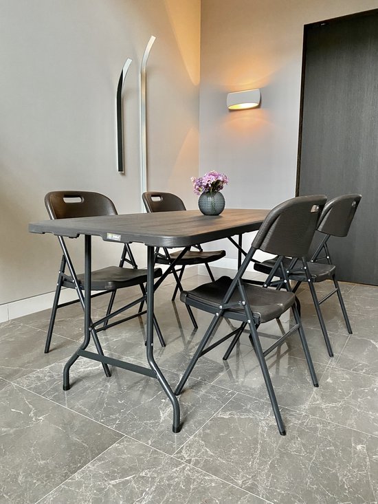 Zwarte klaptafel met vier stoelen, met bloemen op tafel.