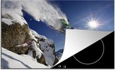 KitchenYeah® Inductie beschermer 80x52 cm - Een actiefoto van een skiër die een jump vanaf een rots maakt - Kookplaataccessoires - Afdekplaat voor kookplaat - Inductiebeschermer - Inductiemat - Inductieplaat mat