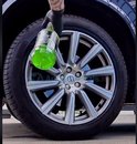 Een persoon spuit met een groene ALU-Teufel fles op een auto velg. De velg is een lichtmetalen exemplaar.