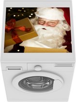 Wasmachine beschermer mat - Een  de kerstman terwijl hij kerstcadeautjes opent - Breedte 55 cm x hoogte 45 cm