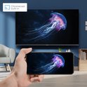 Een telefoon toont een kwall in de oceaan, gespiegeld op een groot tv-scherm met 'Chromecast ingebouwd'-logo.