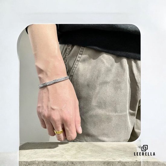 Man draagt zilverkleurige RVS schakelarmband en gouden ring.