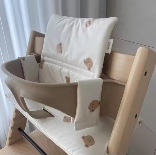 Gros plan du coussin beige à motifs d'ours, avec le texte 'd.d.' sur le coussin de dossier. Le tissu est doux et confortable.