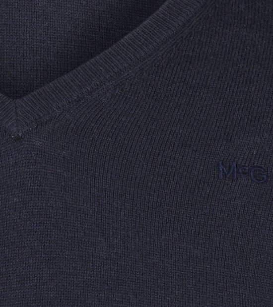 Gedetailleerde opname van het geborduurde 'MG' logo op een marineblauwe V-hals trui.