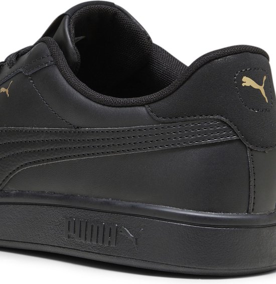 Detail van de hiel van een zwarte Puma Smash sneaker met gouden Puma logo.