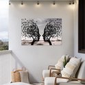 Zwart silhouet van twee bomen met gezichtsprofielen die naar elkaar toe staan, op een balkon.