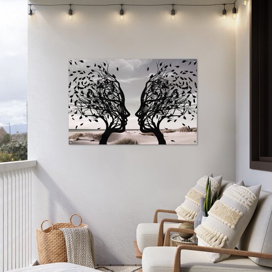 Zwart silhouet van twee bomen met gezichtsprofielen die naar elkaar toe staan, op een balkon.