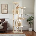 Een beige kattenkasteel van 180 cm hoog met meerdere verdiepingen, zitplaatsen, huisjes en een hangmat. Een oranje kitten staat bovenop.