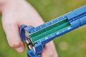 Detail van de blauwe tang, met groene clips en witte schaalverdeling 110, 210, 310.
