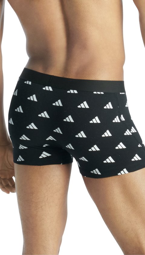 Model van de zijkant in zwarte boxer met herhalend wit Adidas logo.
