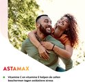 Vrouw met krullen die een man omhelst in een park. ASTAMAX. Vitamine C en E helpen de cellen beschermen tegen oxidatieve stress.