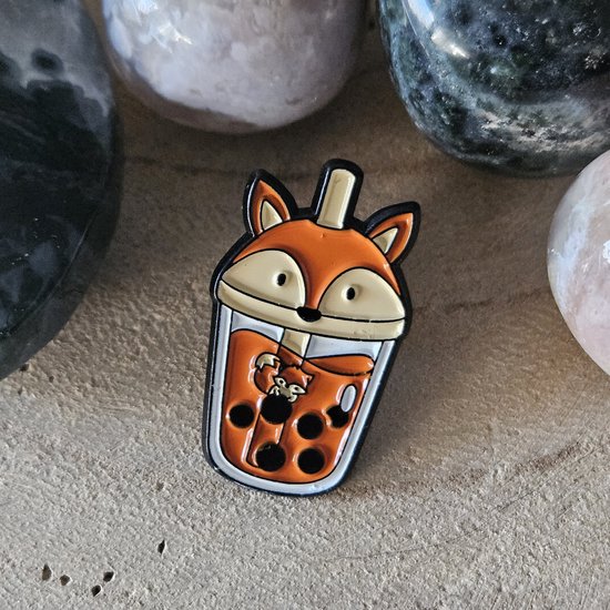 Broche bulle thé orange en forme de renard avec des bulles brunes et un petit renard au centre.