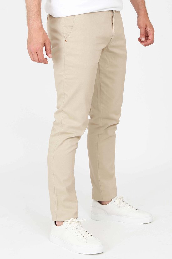 Rechterzijkant van een mannen chino in lichtbeige, gedragen met witte sneakers.