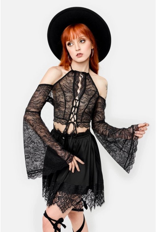 Model in een zwarte kanten crop top met halternek, off-shoulder lange mouwen en vetersluiting aan de voorkant.