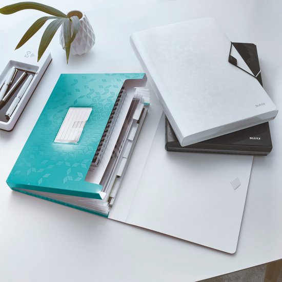 Bureau met een open turquoise map met vakken en een gesloten witte map ernaast.