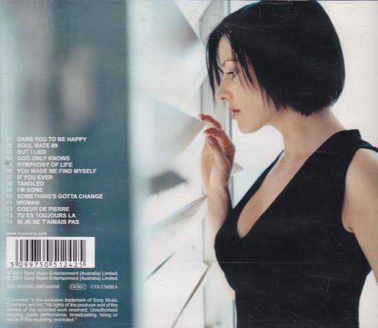 Tina Arena met zwart haar en diepe V-hals top, kijkend naar rechts, met tracklist op de achtergrond.