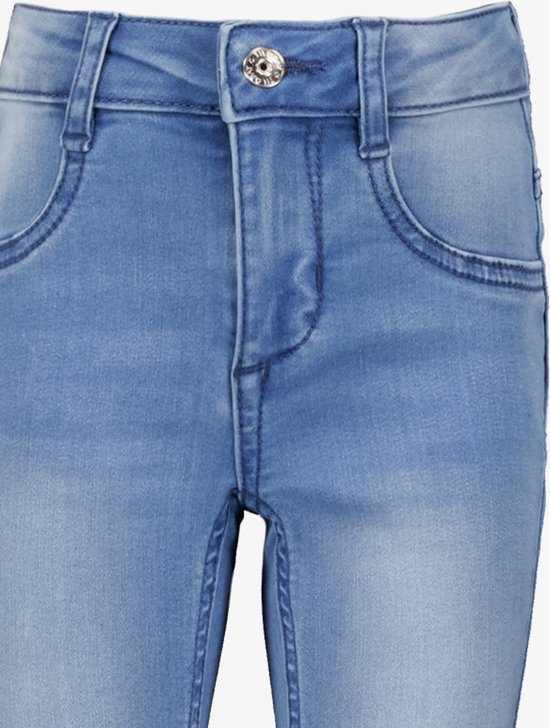 Sluiting van een lichtblauwe skinny jeans met knoop en ritssluiting.