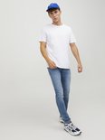 Man draagt een wit T-shirt, blauwe pet en lichte spijkerbroek.