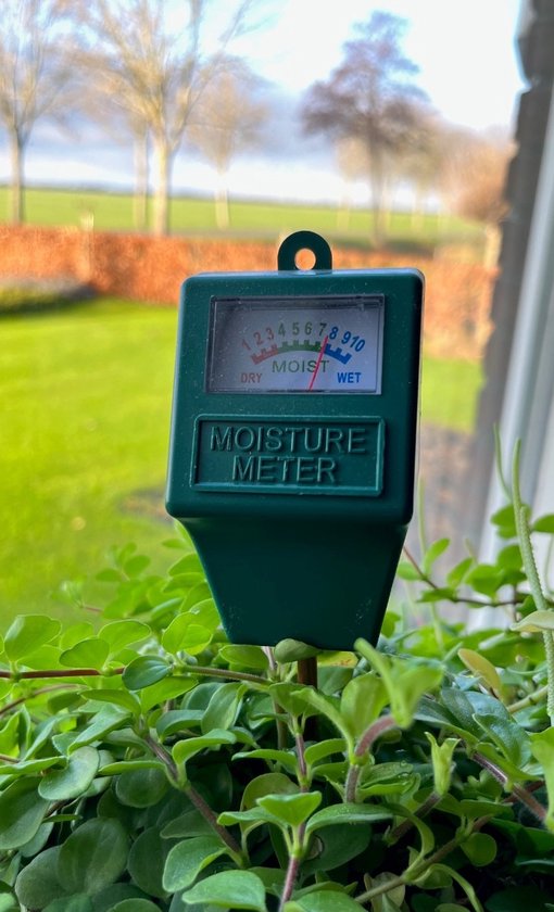 Groene vochtigheidsmeter in planten met een buitenachtergrond.
