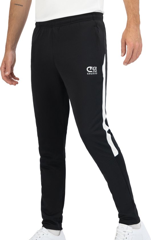 Man draagt een zwarte Cruyff trainingsbroek met witte strepen op de zijkant en geborduurd logo.